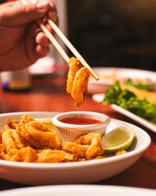 Fried calamari lifted from sweet chili sauce, dripping