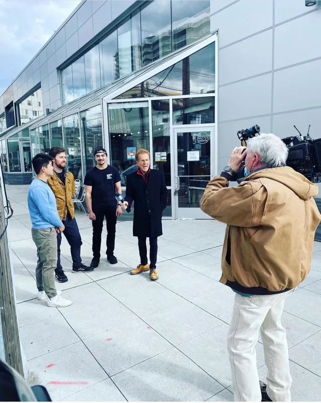 The team on a Fort Lee sidewalk facing a TV camera